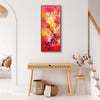 Vibrant abstract landscape painting with warm tones of orange, red, and yellow hanging on white wall in modern home decor setting with wooden console table and decorative elements.