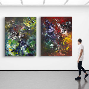 Large abstract paintings in bold, earthy colors displayed on gallery walls. The vibrant artwork features a mix of greens, blues, reds, and yellows, creating a dynamic, expressive visual composition. The paintings are hung in a modern, minimalist gallery setting, complementing the clean, bright space.