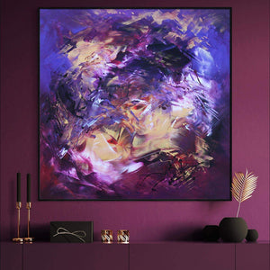 Large abstract square canvas painting with vibrant purple, blue, and warm tones, showcasing a bold and expressive modern art style. Prominently displayed on a purple wall with complementary decor elements like gold candle holders and a vase.