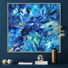 Vibrant abstract seascape canvas art with swirling blue and teal brushstrokes, framed and displayed in a modern interior setting.
