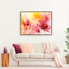Vibrant abstract painting with warm tones of pink, orange, and yellow, displayed in a modern white living room setting with a beige sofa, decorative pillows, and potted plants.