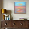 Abstract Seascape | Pearl Sunset 28x28" - Vibrant abstract painting depicting a serene sunset over the ocean, placed on a wooden console table with decorative elements.