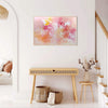 Colorful abstract art | Vibrant floral painting in pink, yellow, and white hues displayed on a white wall in a modern, minimalist interior with natural wood furnishings.