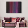 Large abstract painting of colorful geometric patterns in shades of purple, pink, and black, displayed above a plush purple sofa with decorative throw pillows in the living room setting.