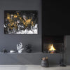 Abstract landscape painting featuring dynamic black, white, and golden brush strokes against a dark background, displayed on a wall in a cozy living space with a fireplace and decorative accents.
