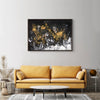 Framed abstract landscape painting featuring dramatic black, white, and gold brushstrokes on a dark background, displayed on a wall above a yellow sofa in a modern living room setting.