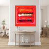 Vibrant abstract painting | Geometric Art | Secret Path 38x38" - Bold red and gold abstract canvas art displayed on a white wall in a modern, minimalist home setting with wooden furniture and decor elements.