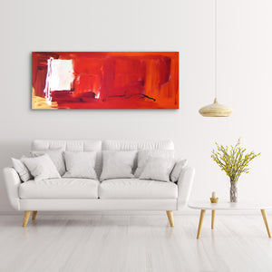 Large abstract red canvas art with bold brushstrokes and vibrant colors, displayed on a white wall above a gray sofa and surrounded by modern home decor elements.