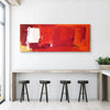 Large abstract red painting with expressive brushstrokes on white wall above modern wooden table and stools in contemporary home interior.
