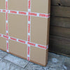 Stacked fragile boxes with red warning labels on a wooden floor