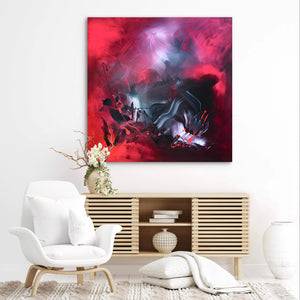 Vibrant abstract painting with swirling red, purple, and black hues displayed on a white wall above a modern wooden media console.