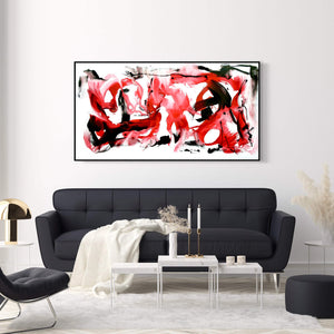 Large abstract painting titled "Gestural Painting | Crimson Tide 32x60" featuring vibrant red and black expressive brushstrokes against a light background, displayed in a modern living room setting with a black sofa, coffee table, and other minimalist decor.