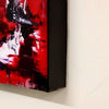 Vibrant abstract artwork in red and black tones, showcased on a white wall.