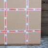 Fragile cartons stacked on a wooden floor, with "FRAGILE" warning labels clearly visible across the surface of the boxes.