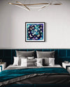 Elegant modern bedroom with framed abstract artwork on the wall depicting colorful butterflies on a dark background. The artwork is the focal point, complemented by the sophisticated grey and teal bedding and the contemporary lighting fixture overhead.