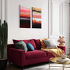 Diptych abstract art, Caramel Dunes I and II, modern landscape paintings in vibrant colors, displayed on the wall above a cozy burgundy sofa with patterned throw pillows, creating a stylish and inviting living room decor.